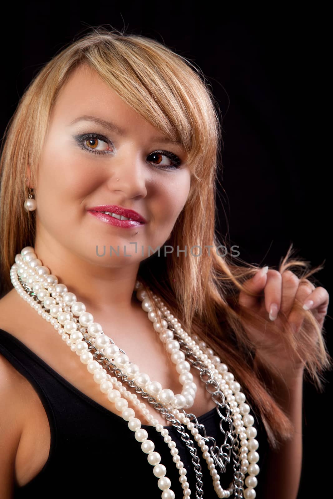 Young blonde Woman in a black top with pearl necklaces