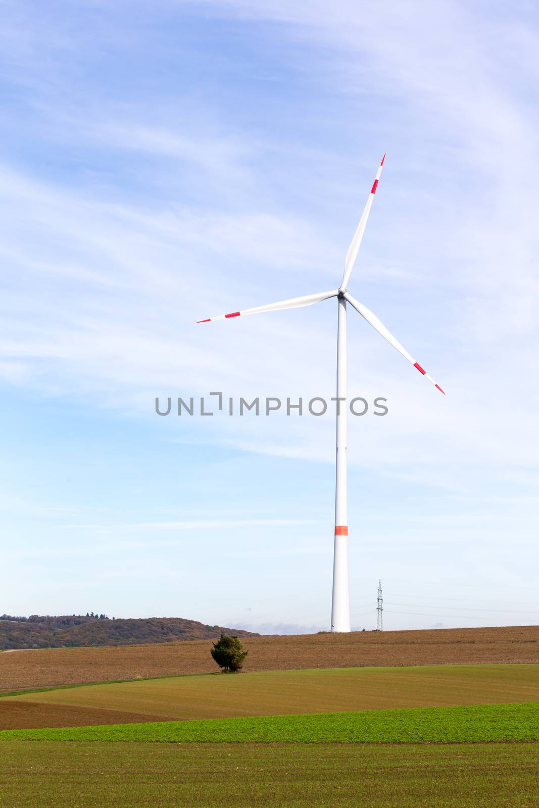 A windmill on a field with blue sky by 25ehaag6