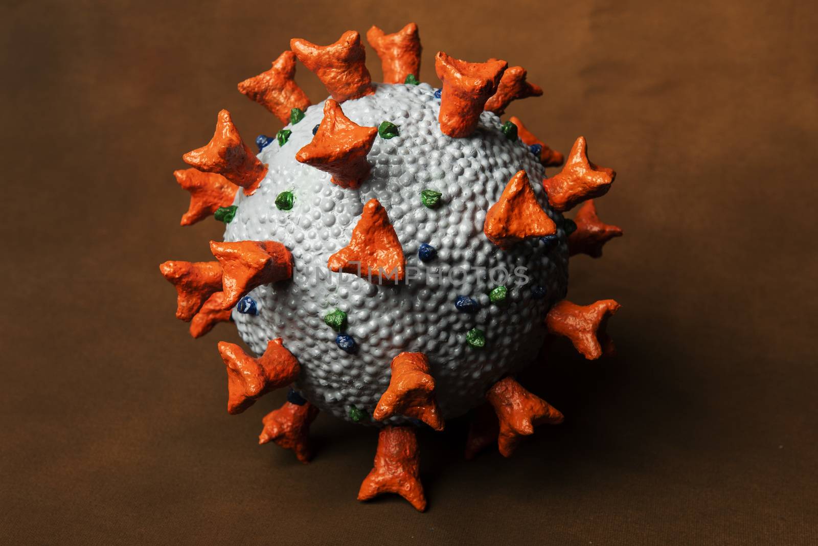 Homemade realistic model of Corona Virus SARS-CoV-2 used as a tool for science education for students in school. Dangerous coronavirus caused global pandemy in COVID-19 respiratory disease. On a brown background