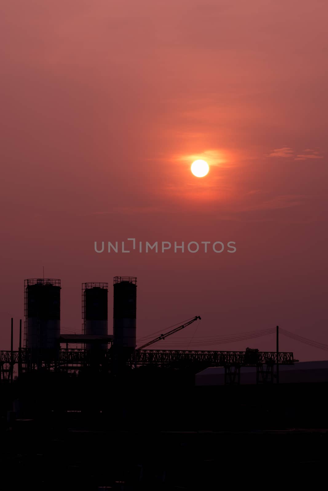 sunset over the silhouette industrial factory. by wattanaphob