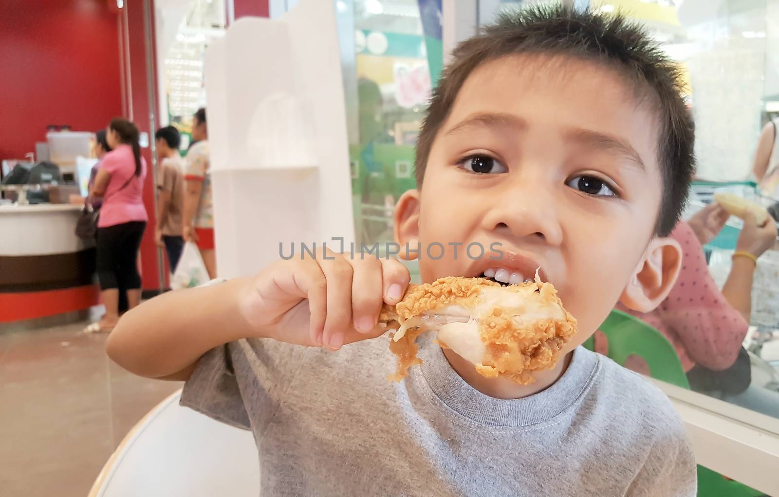 Cute Asian boy eating fried chicken is delicious.