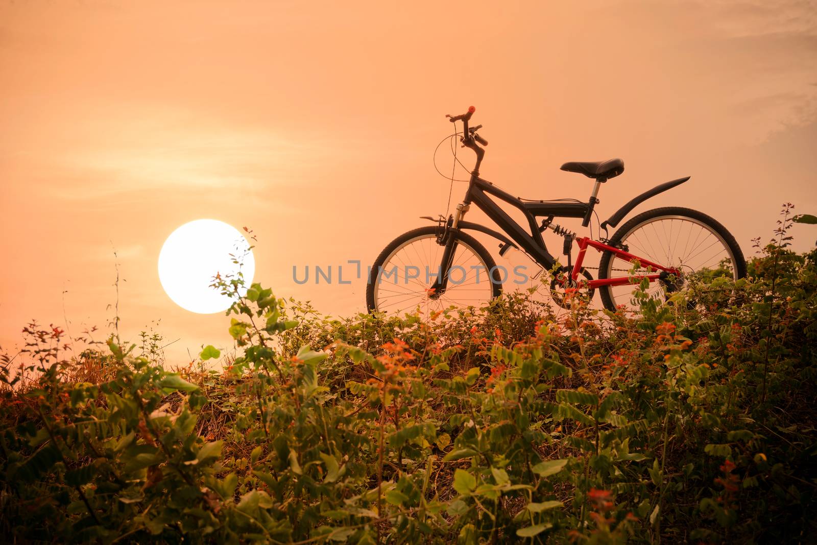 mountain bike with a colorful sky and sunset. by wattanaphob