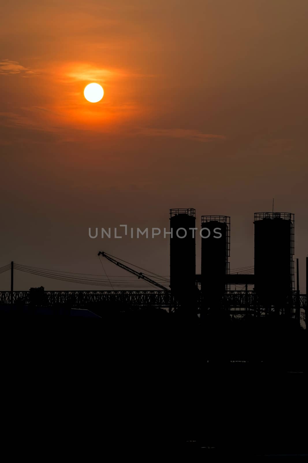 sunset over the silhouette industrial factory. by wattanaphob