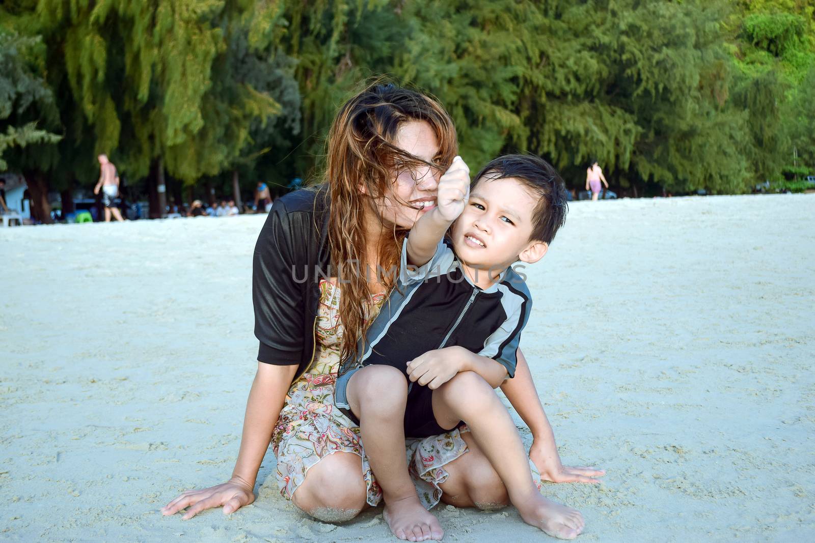 Mother and son teasing each other playfully on the beach on the weekend.