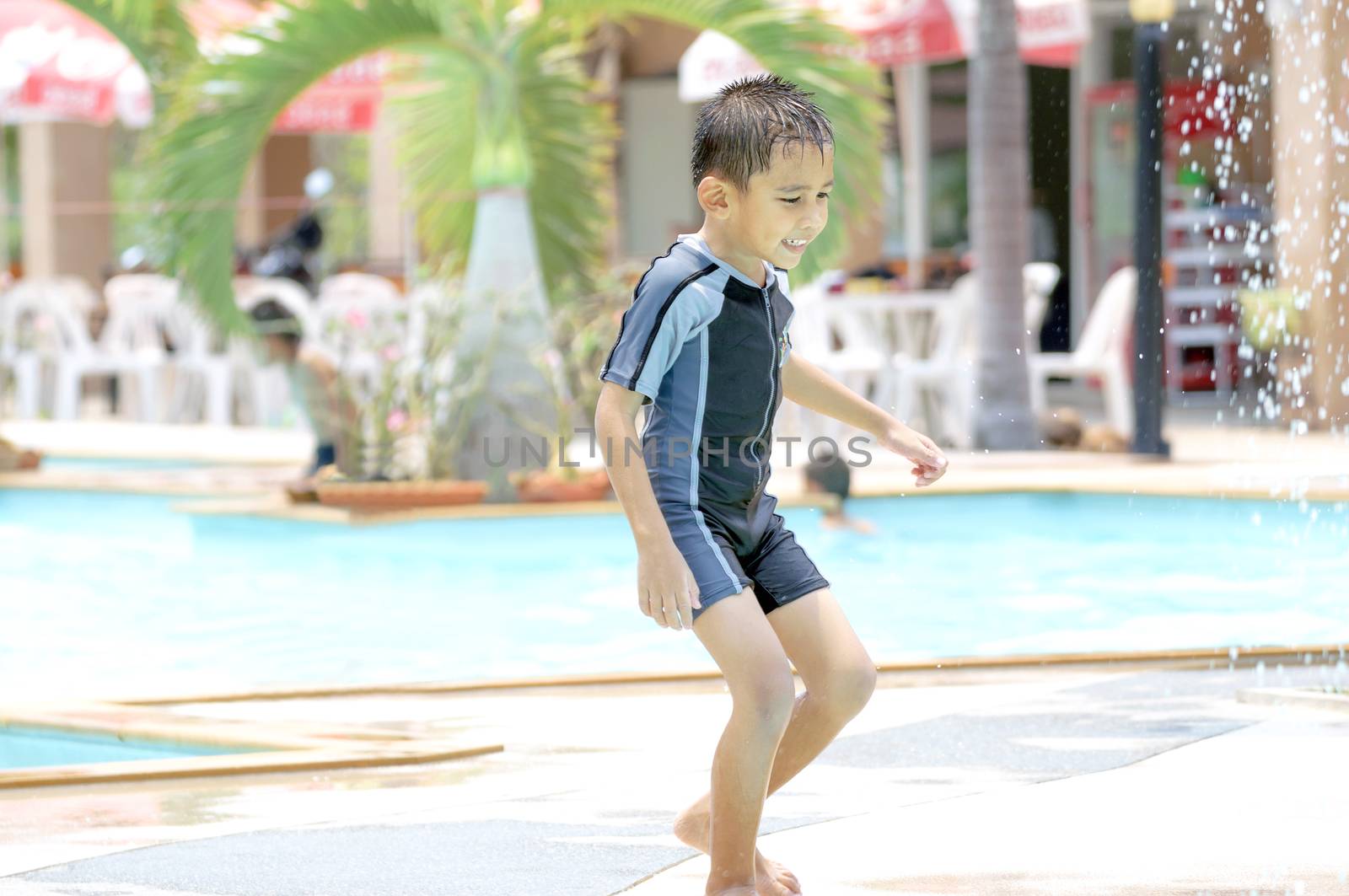 Asian boy in swimwear, swimming fun in the pool.