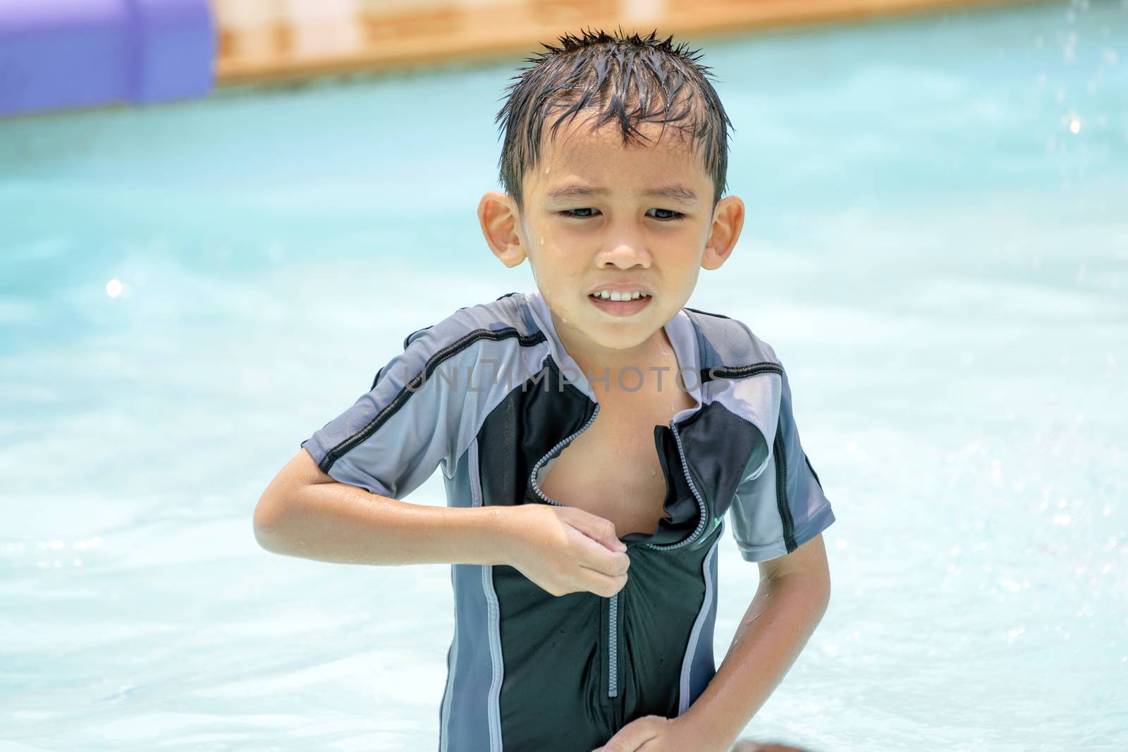 Asian boy in swimwear, swimming fun in the pool.