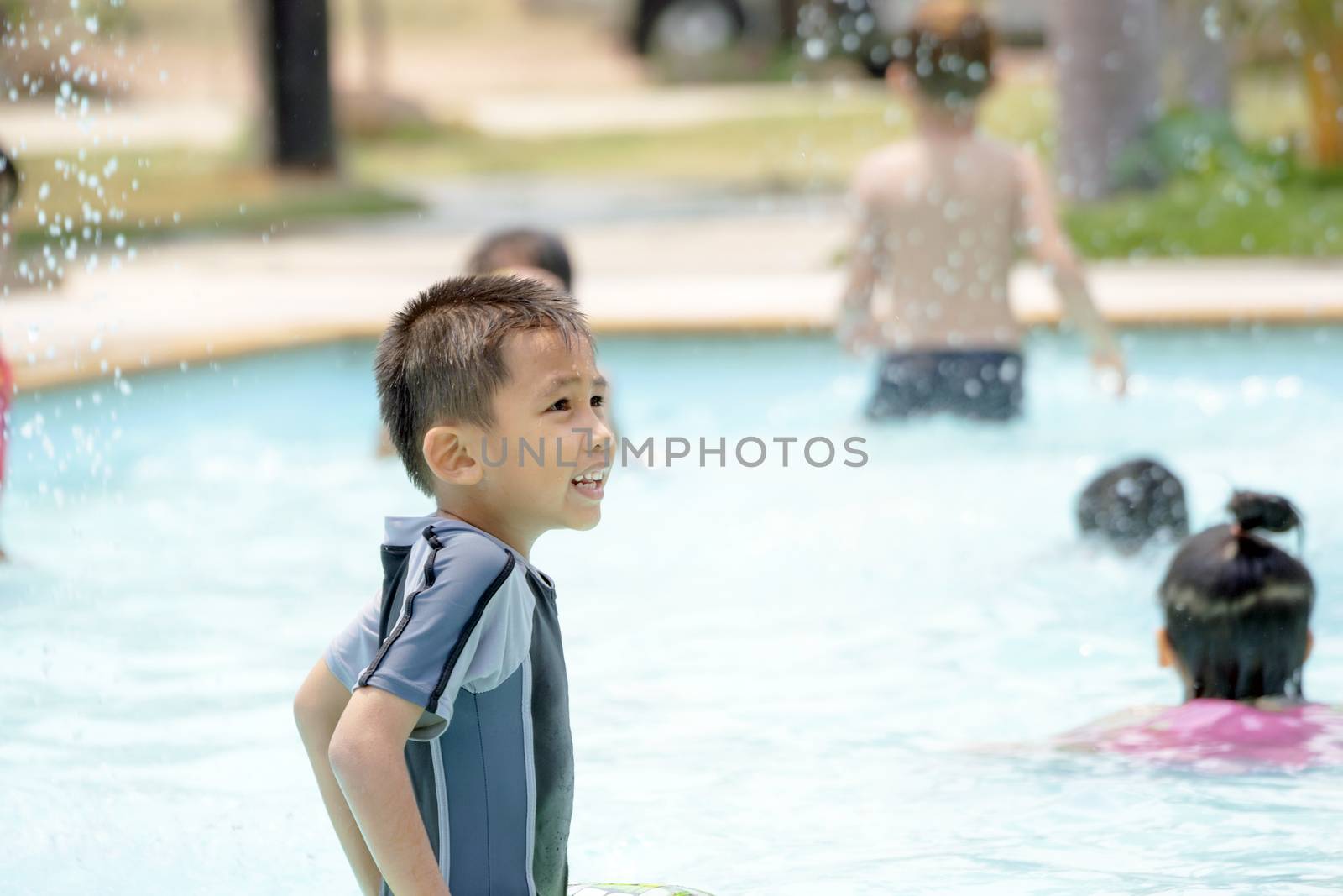 Asian boy in swimwear, swimming fun in the pool.