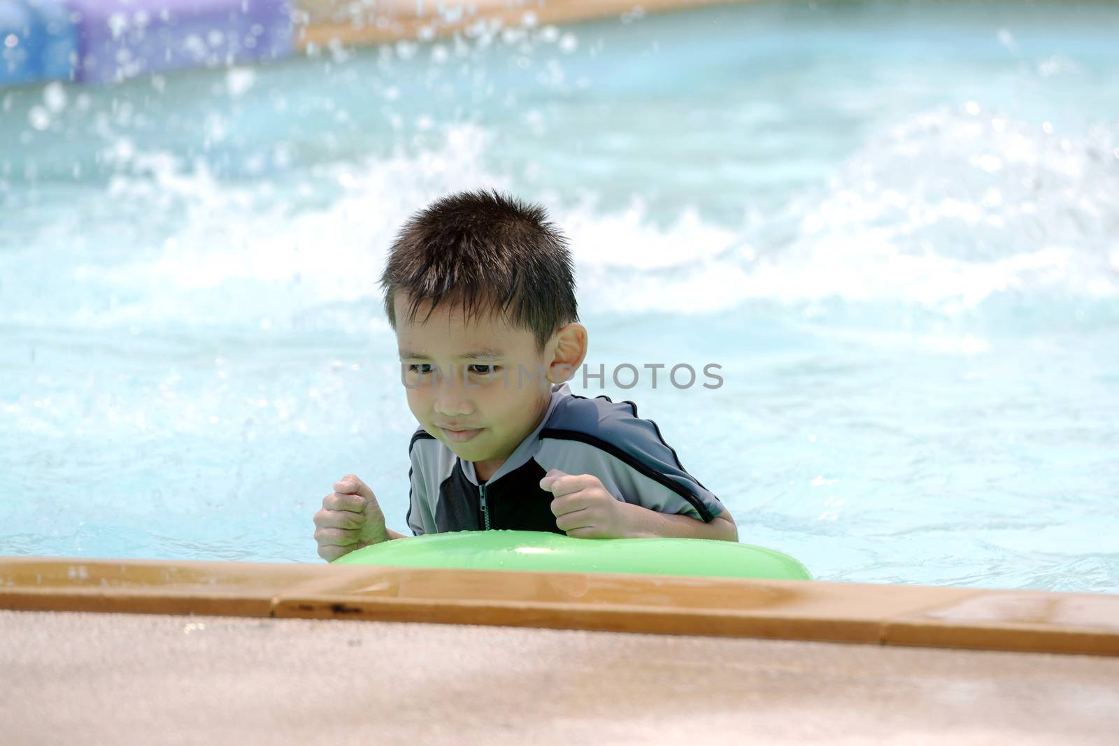 Asian boy in swimwear, swimming fun in the pool.