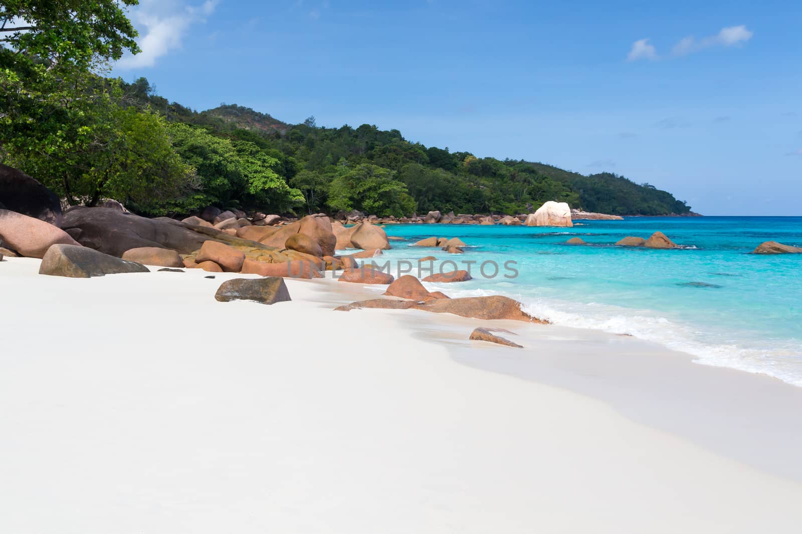 The beach of the Seychelles with blue water and stones
