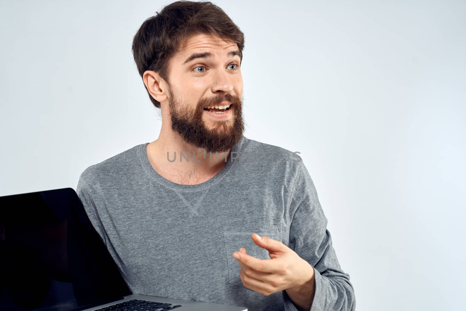 A man in a gray sweater with a laptop hands lifestyle technology communication internet work by SHOTPRIME