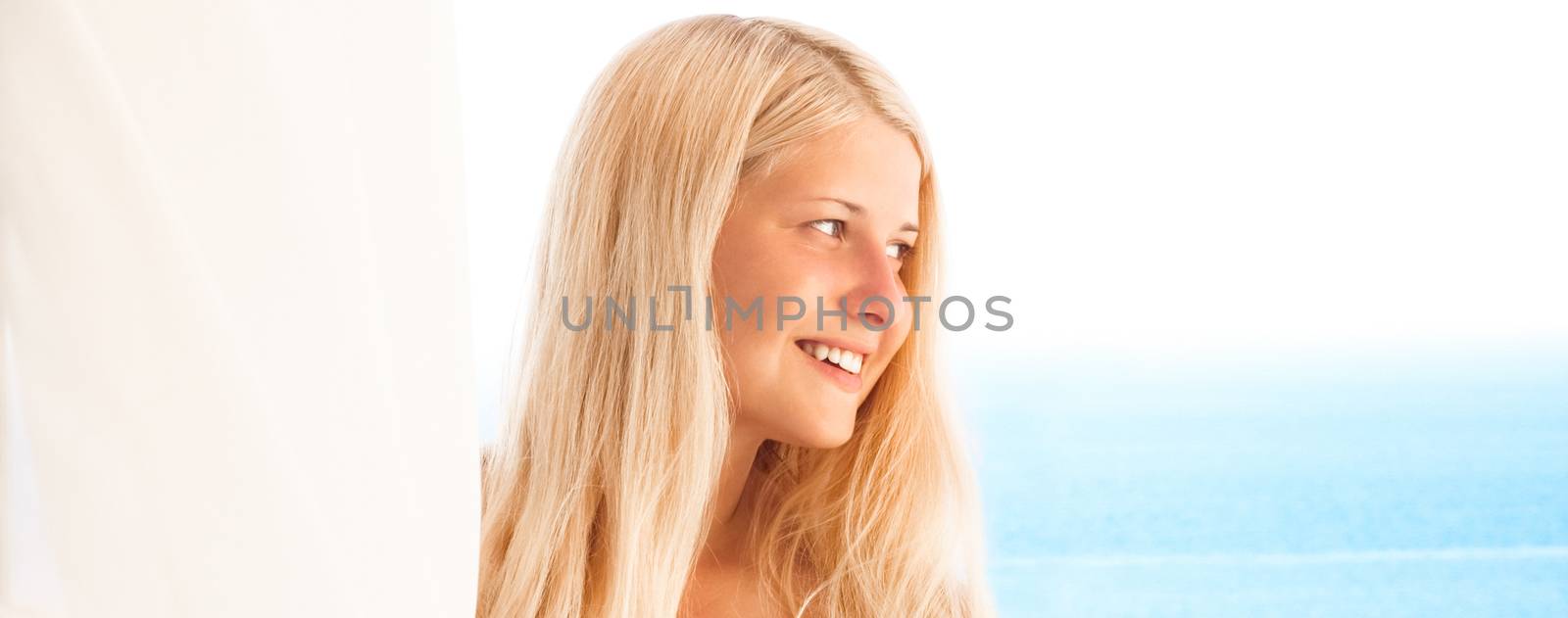 Woman with blond hair enjoying seaside and beach lifestyle in su by Anneleven