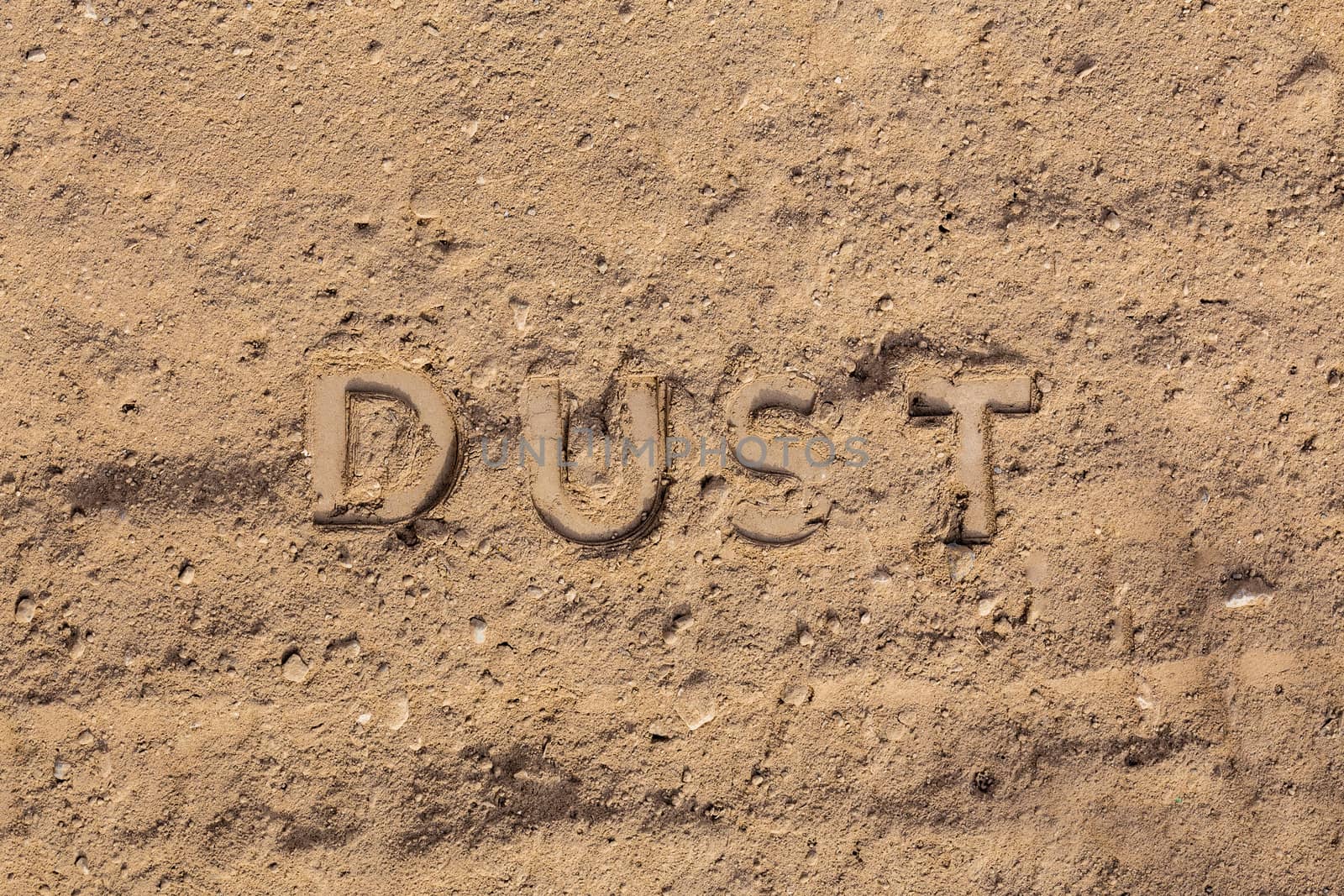 the word dust embossed on dusty road surface - close-up flat lay perspective under direct sunlight