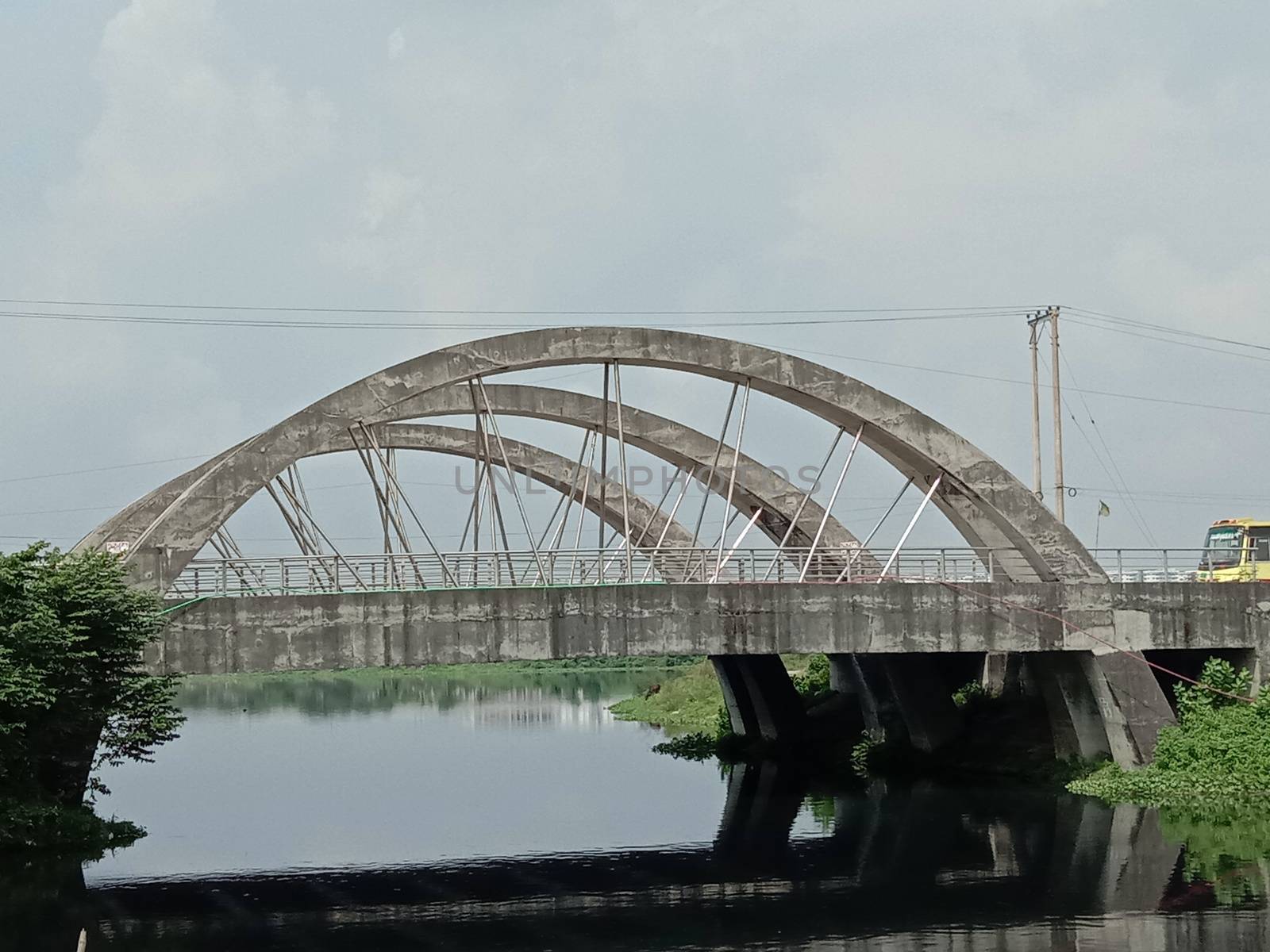 stylish steel and concrete bridge on lake with nature