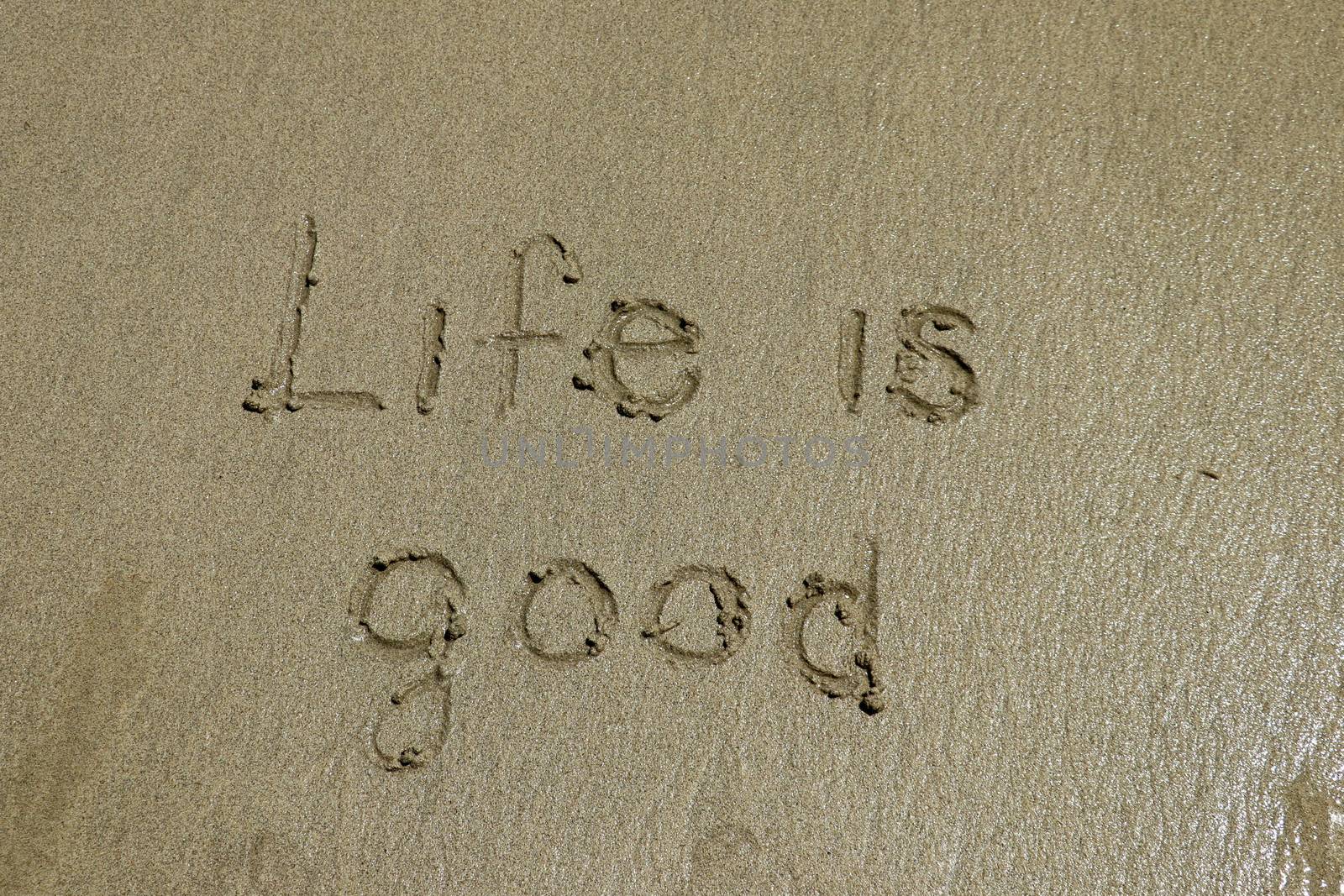 Life is good - positive thinking concept. Inspiration and motivation quote. The sign written on sand.