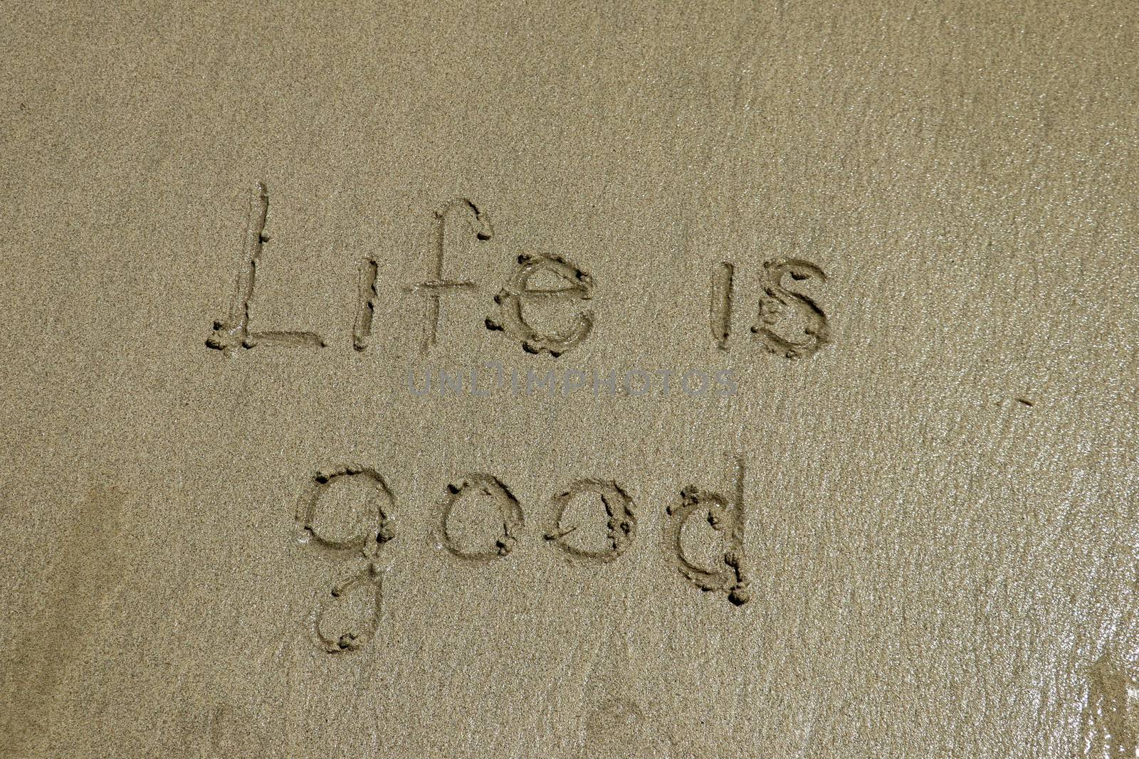 Life is good - positive thinking concept. Inspiration and motivation quote. The sign written on sand.