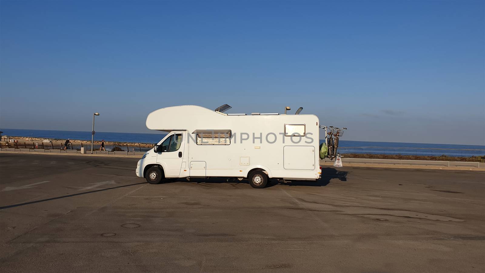Recreational vehicle in the middle of beach empty parking lot by HD_premium_shots