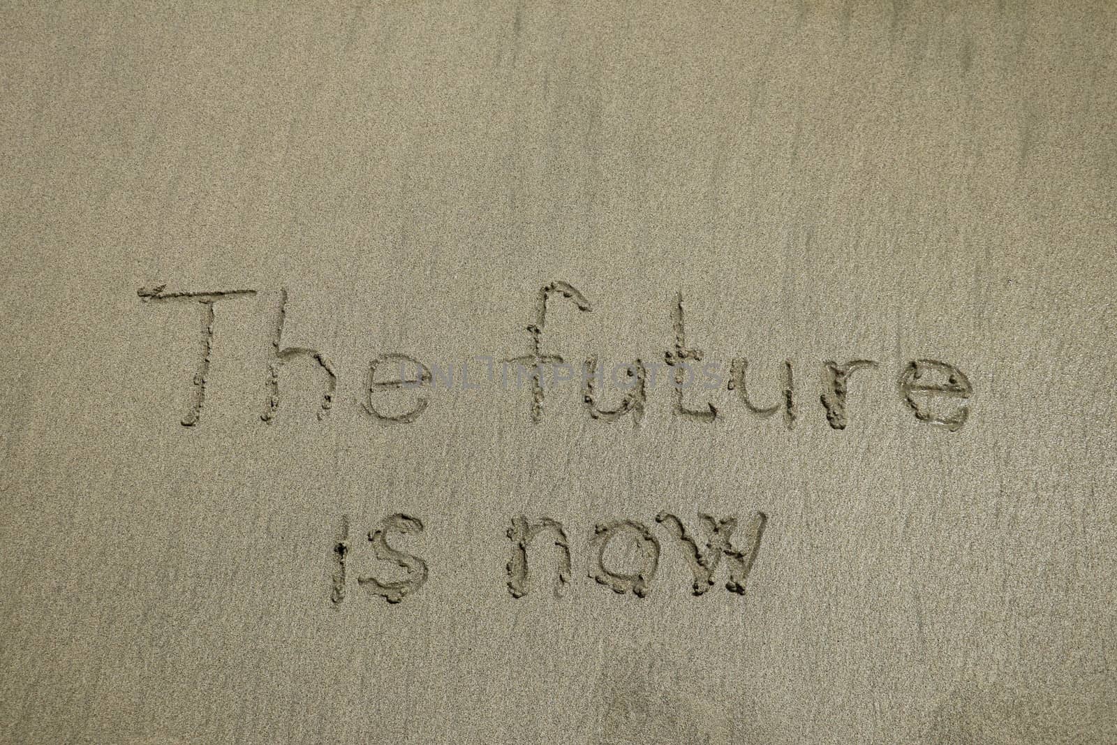 The future is now, innovative technology concept text written on sand.