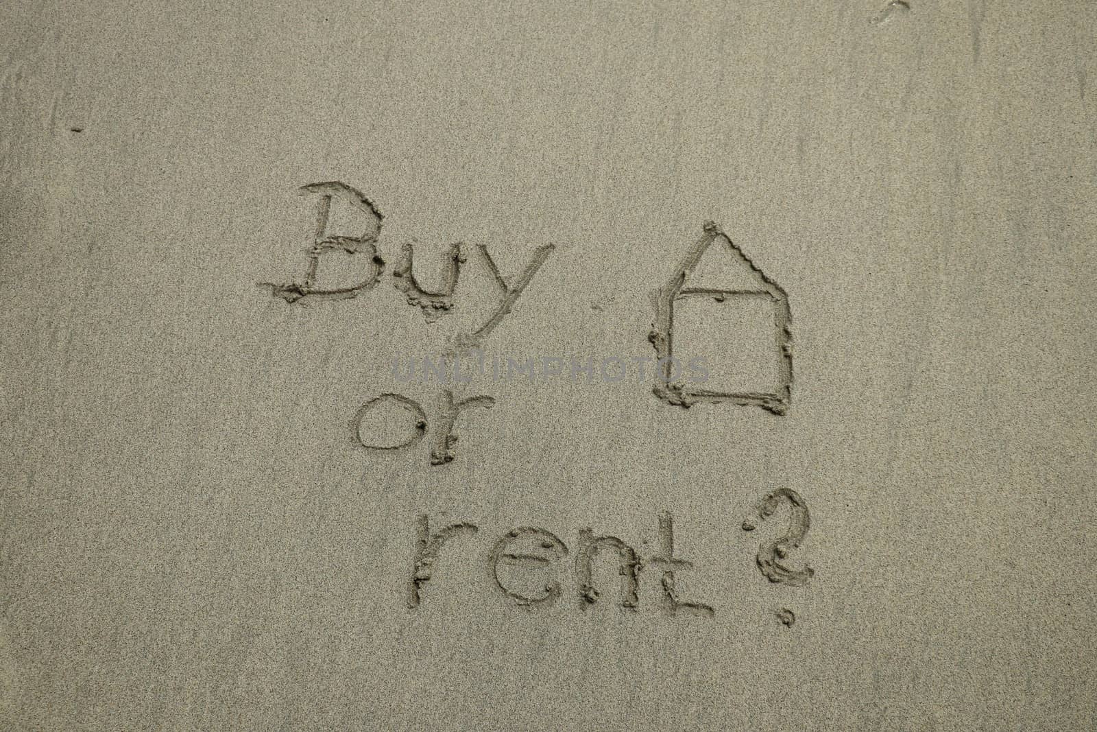 buy or rent concept, text on the sand, real estate. The sign written on sand.