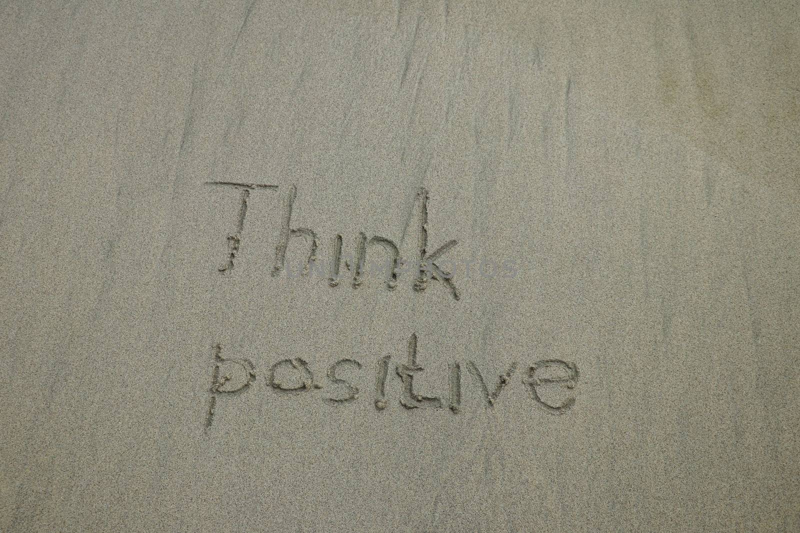 think positive written on the sand beach - positive thinking concept.