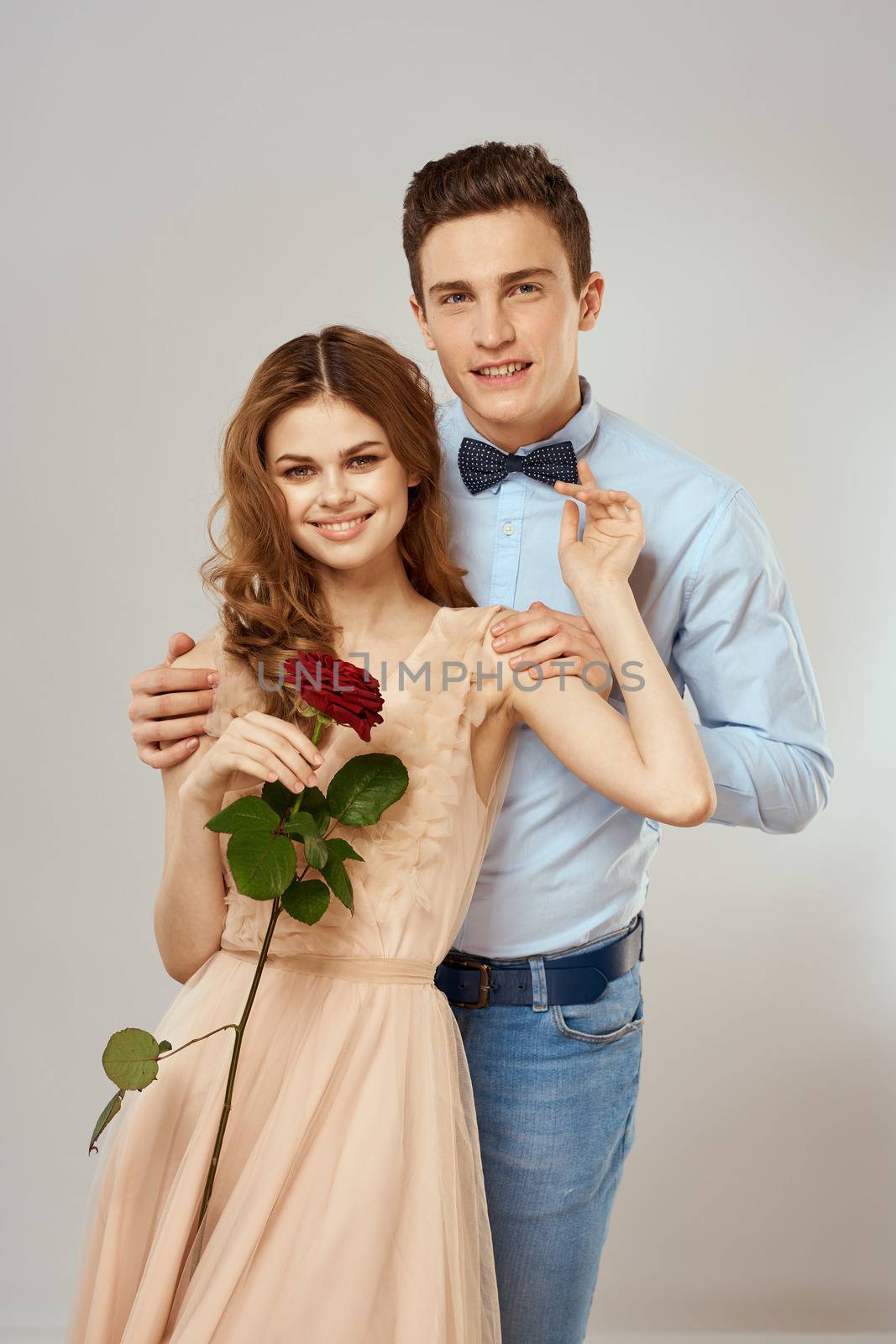 Young couple romance hug relationship dating red rose light studio background by SHOTPRIME