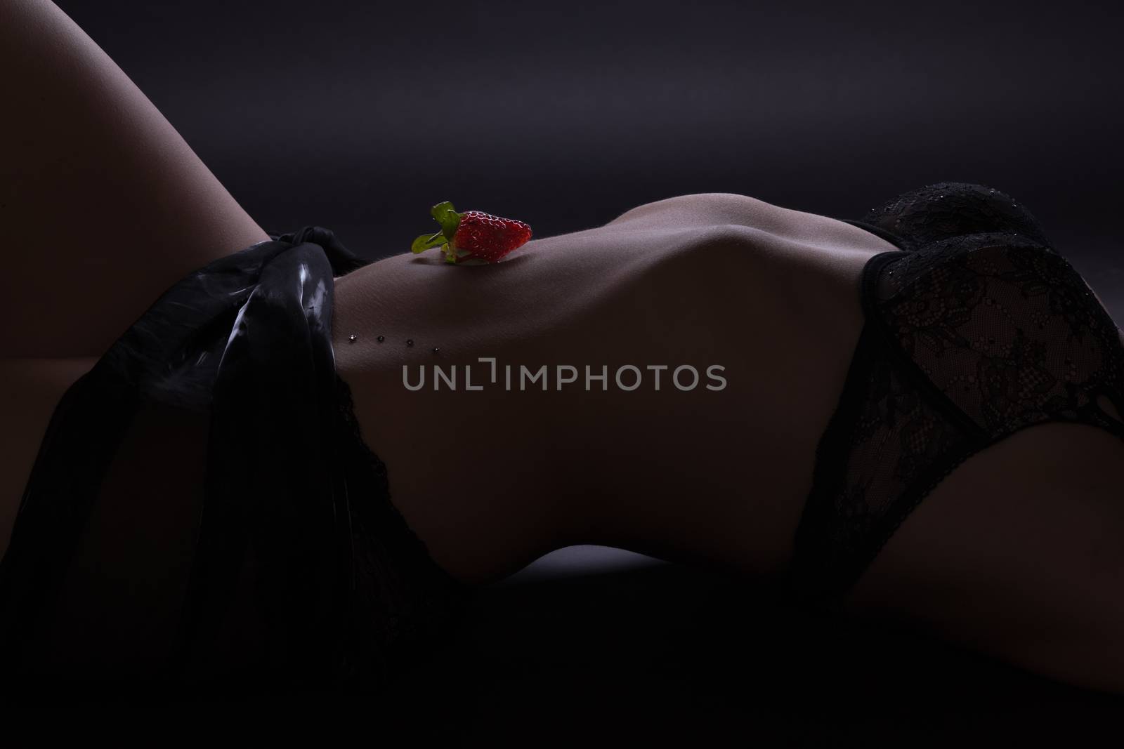 lying woman with strawberry on belly