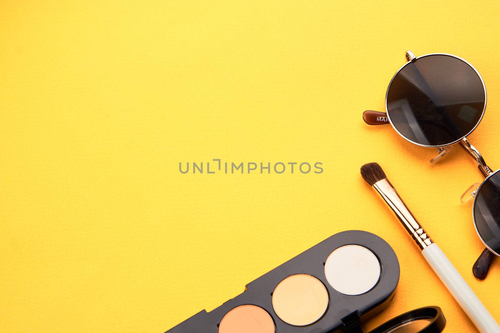 Professional eyeshadows and makeup brushes on a yellow background make-up decoration. High quality photo