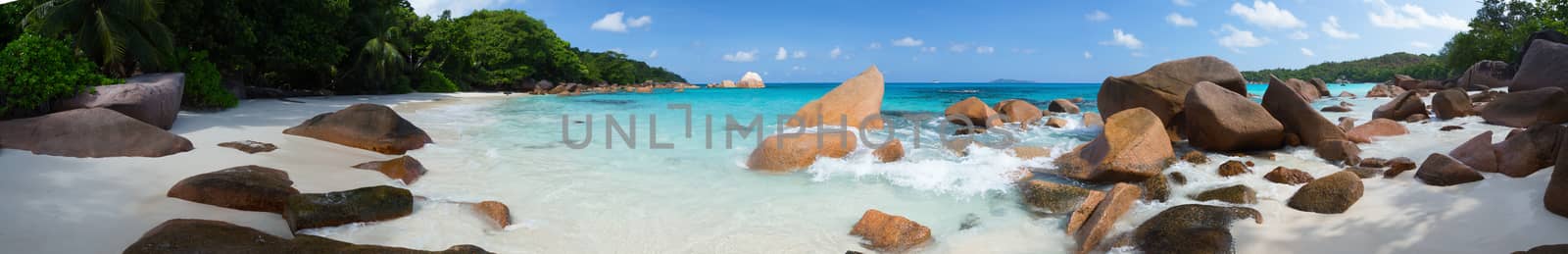 Panorama of the beach with big stones and white sand and a blue sky