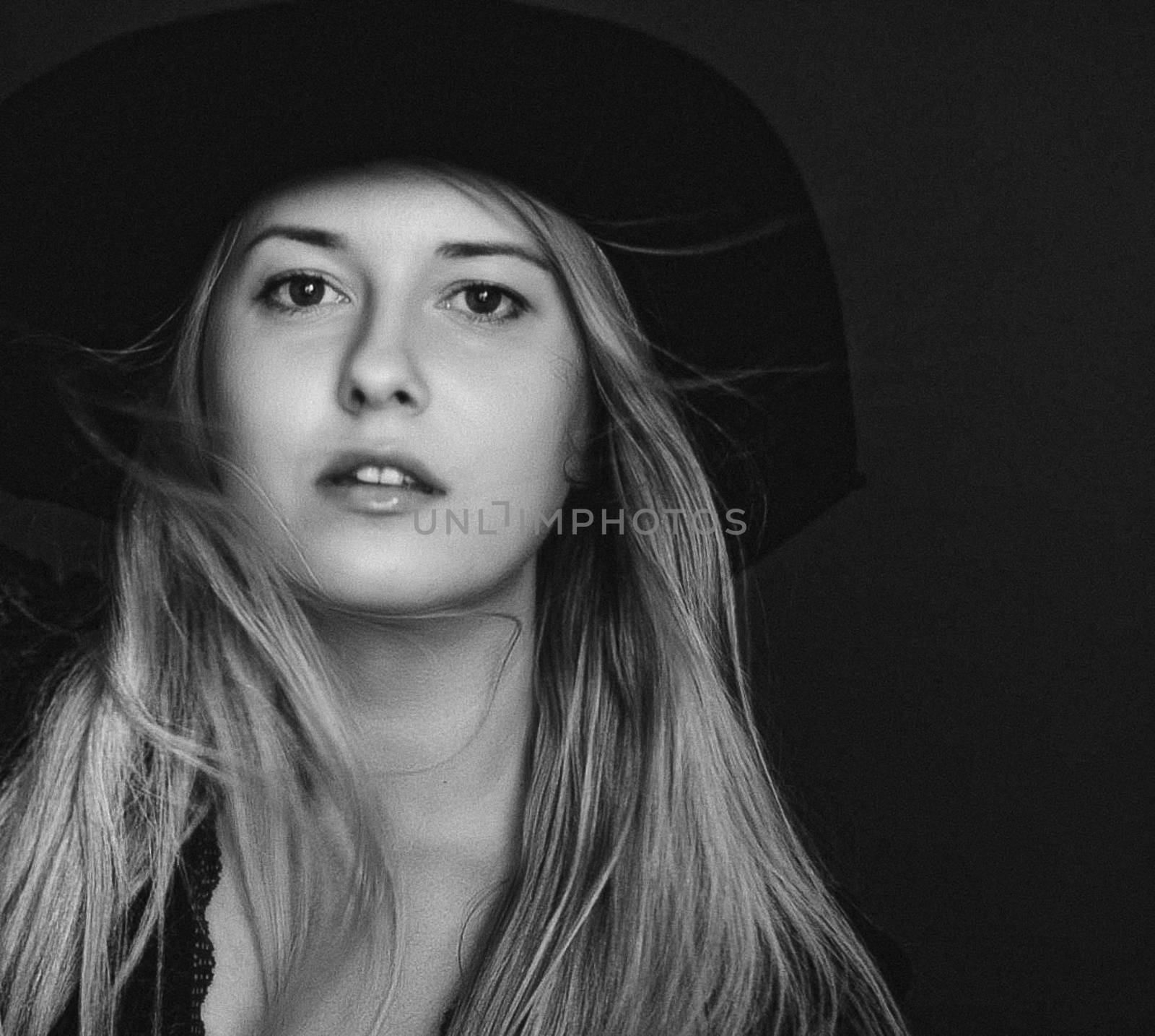 Beautiful blonde woman wearing a hat, artistic film portrait in black and white for fashion campaign and beauty brands