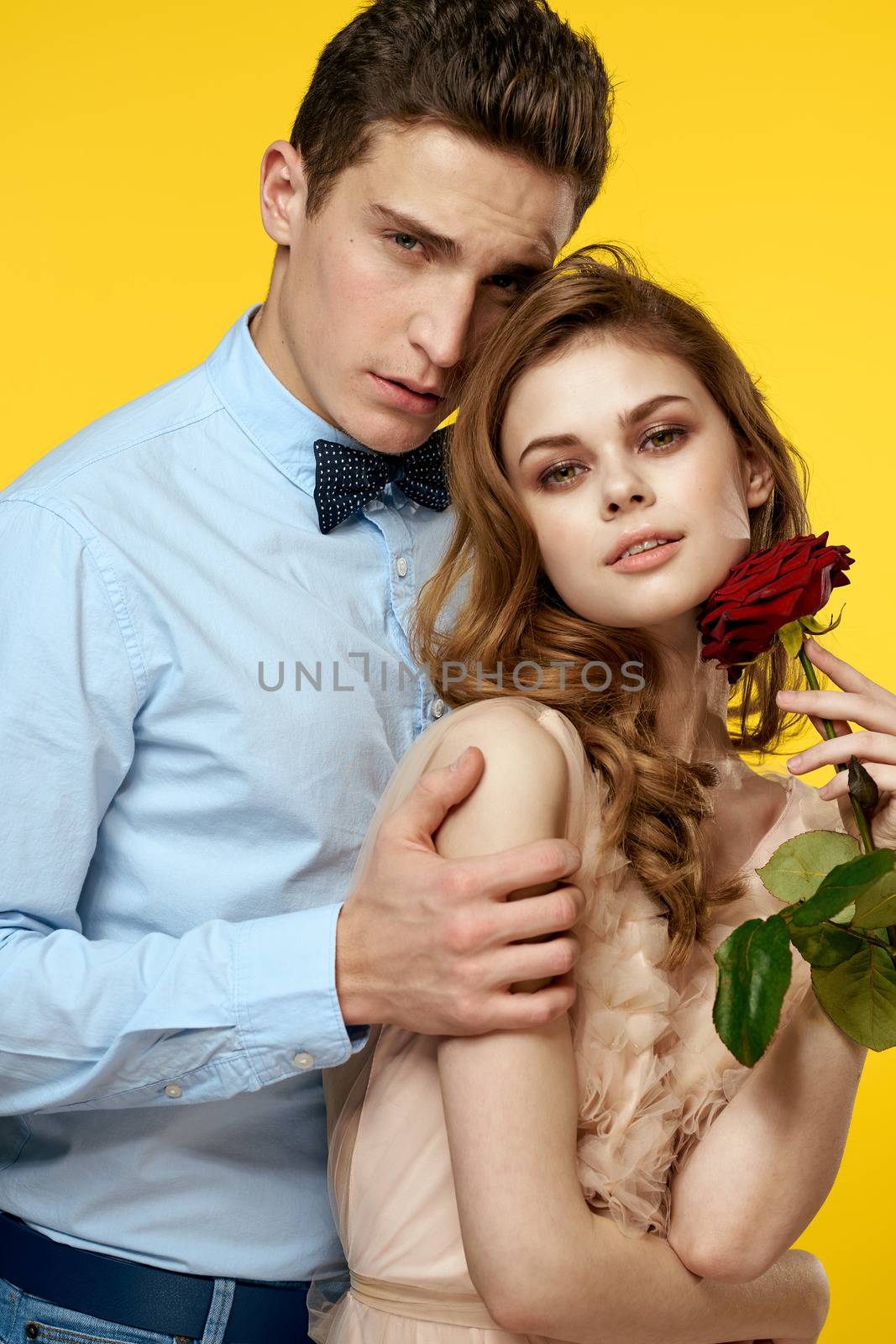 Enamored man and woman with red rose on yellow background cropped view close-up romance by SHOTPRIME