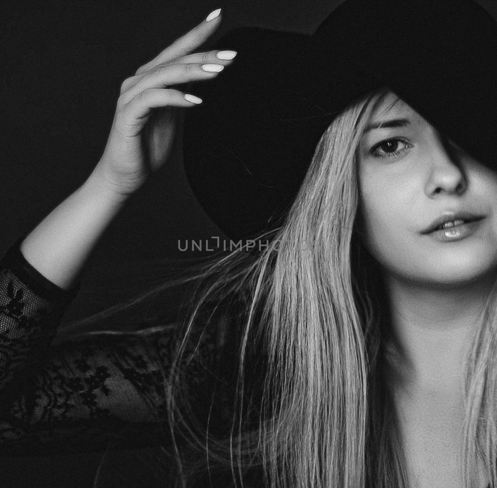 Beautiful blonde woman wearing a hat, artistic film portrait in black and white for fashion campaign and beauty brands