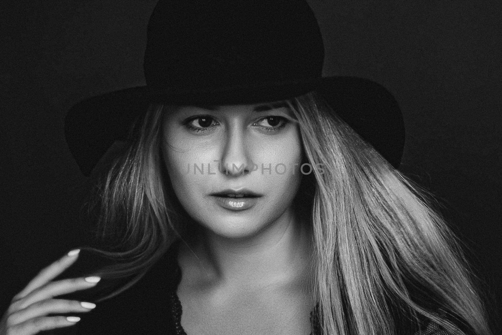 Beautiful blonde woman wearing a hat, artistic film portrait in black and white for fashion campaign and beauty brands