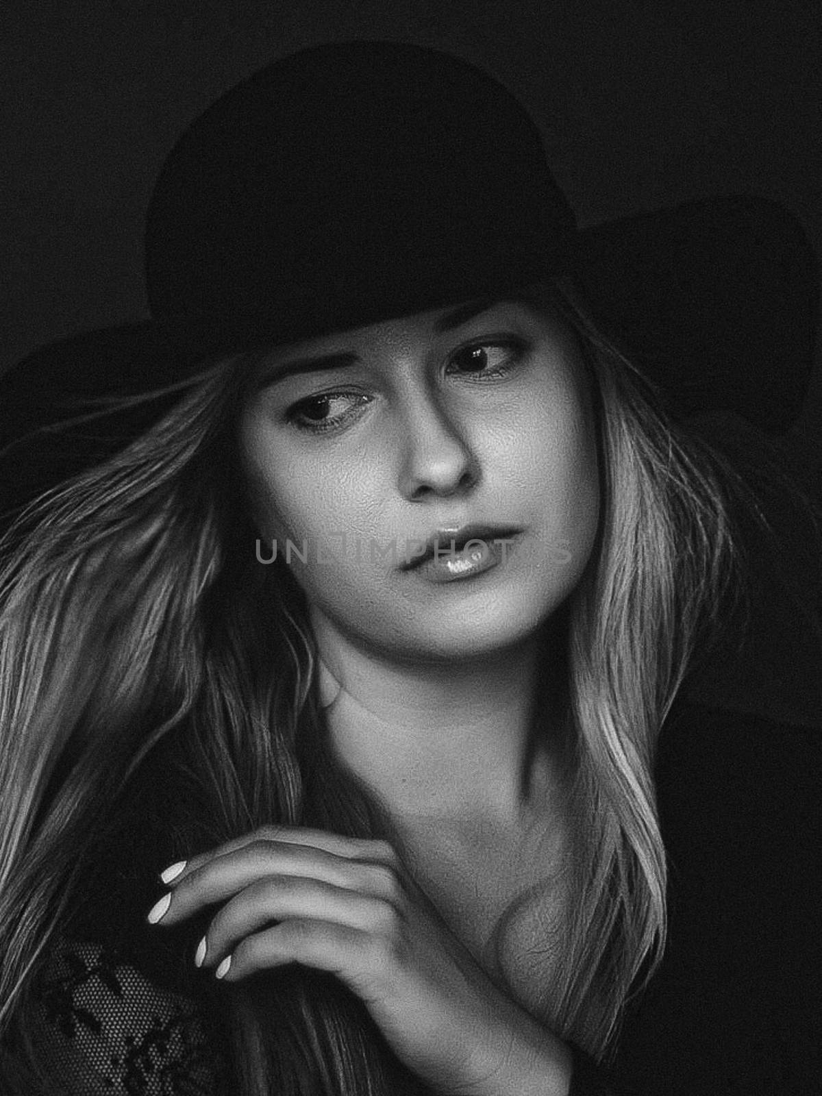 Beautiful blonde woman wearing a hat, artistic film portrait in black and white for fashion campaign and beauty brands