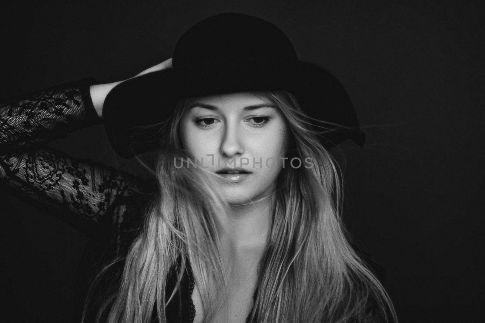 Beautiful blonde woman wearing a hat, artistic film portrait in black and white for fashion campaign and beauty brands