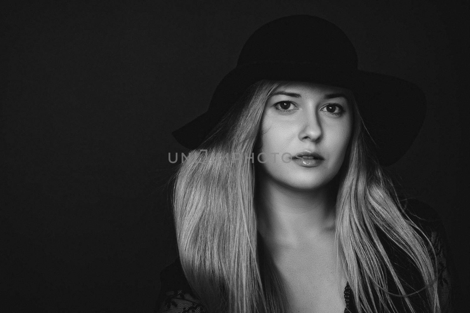 Beautiful blonde woman wearing a hat, artistic film portrait in black and white for fashion campaign and beauty brands