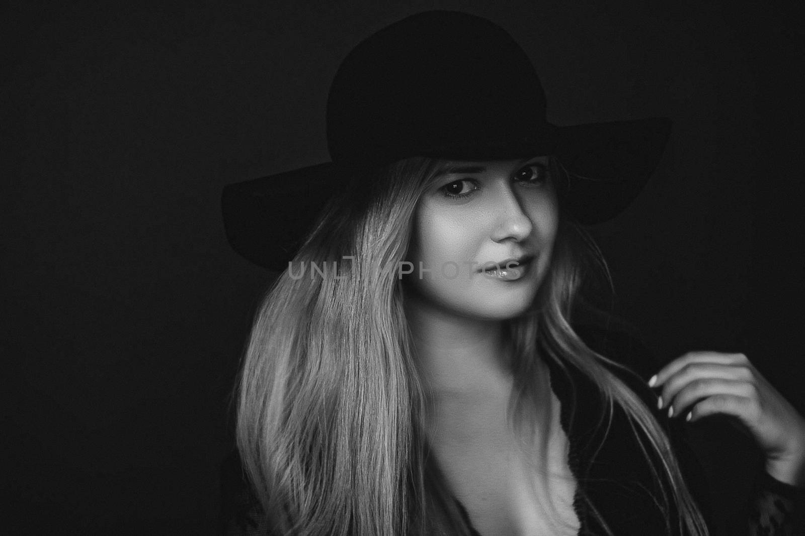 Beautiful blonde woman wearing a hat, artistic film portrait in black and white for fashion campaign and beauty brands