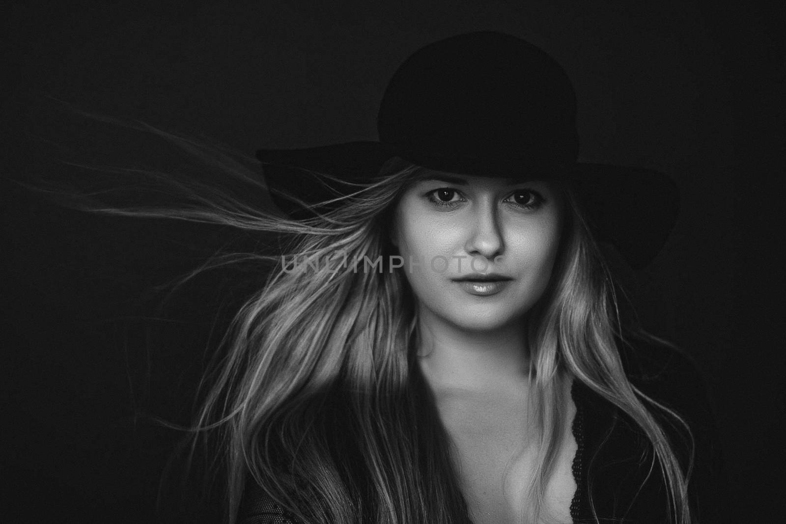 Beautiful blonde woman wearing a hat, artistic film portrait in black and white for fashion campaign and beauty brands
