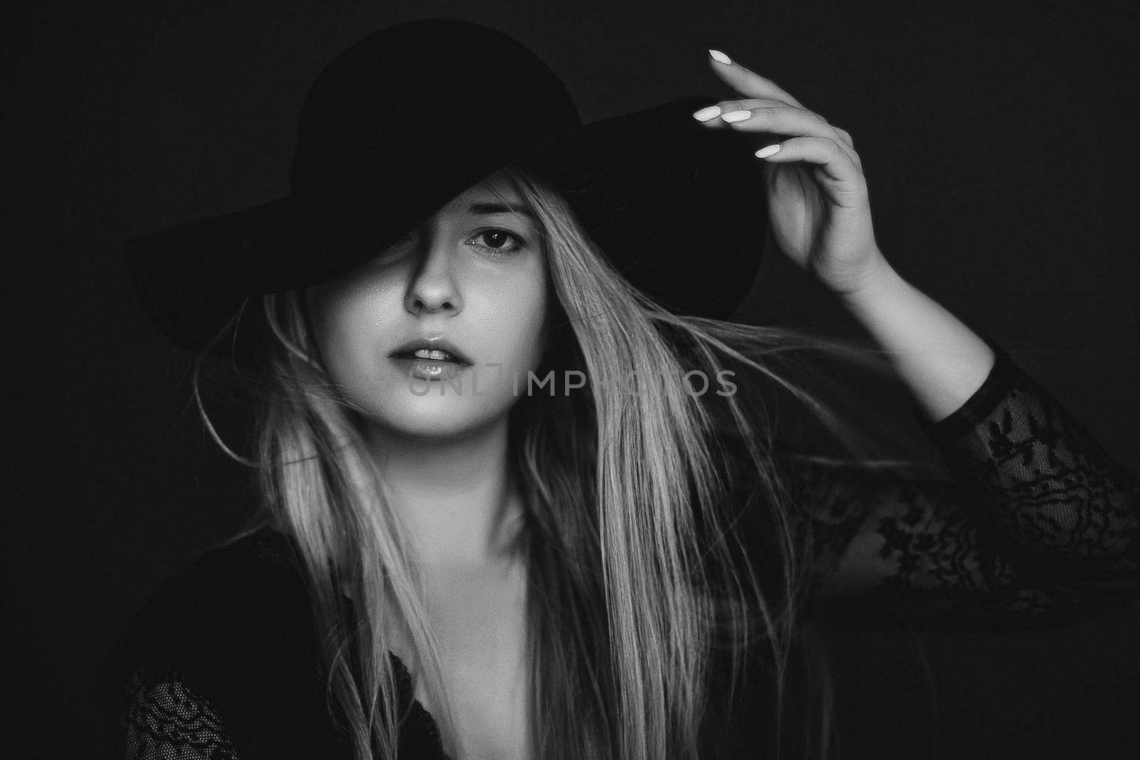 Beautiful blonde woman wearing a hat, artistic film portrait in black and white for fashion campaign and beauty brands