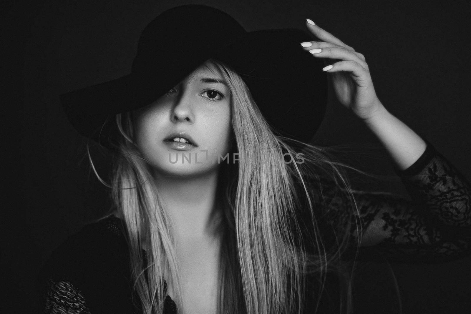 Beautiful blonde woman wearing a hat, artistic film portrait in black and white for fashion campaign and beauty brands