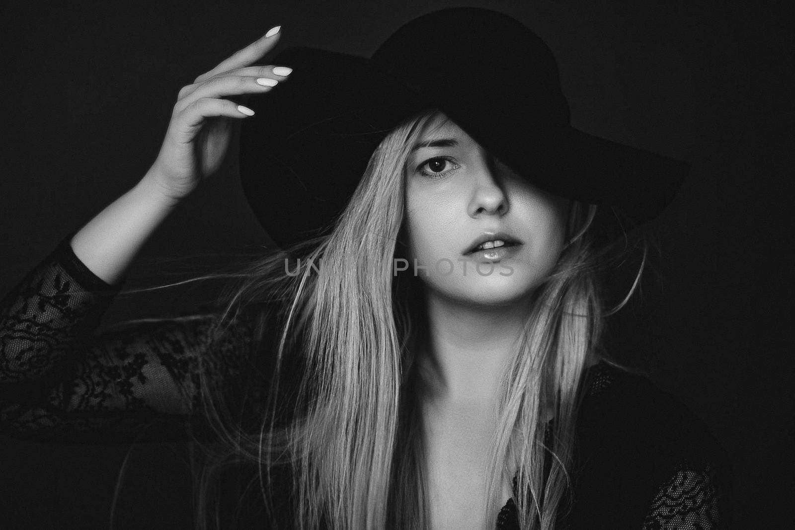 Beautiful blonde woman wearing a hat, artistic film portrait in black and white for fashion campaign and beauty brands