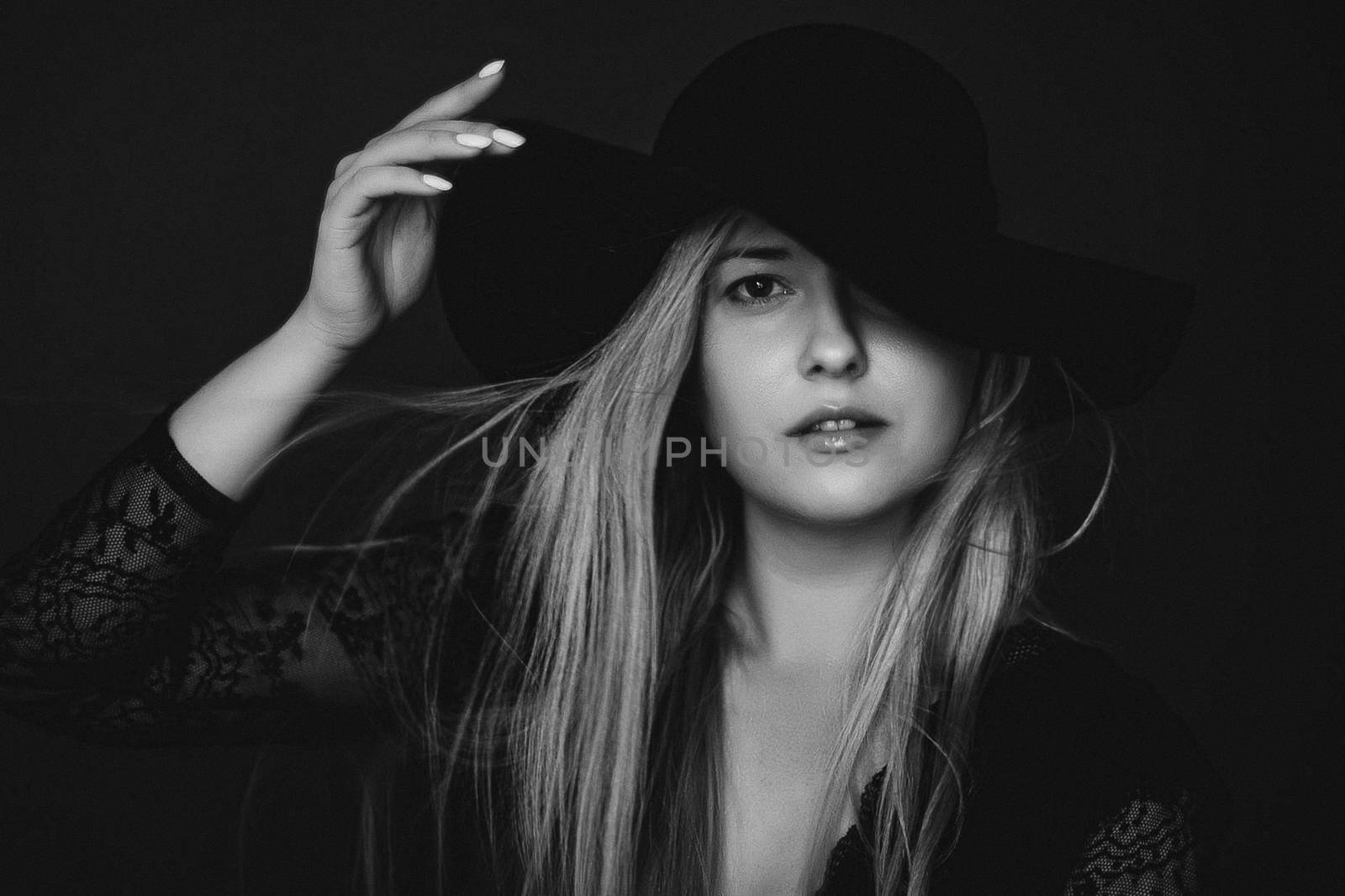 Beautiful blonde woman wearing a hat, artistic film portrait in black and white for fashion campaign and beauty brands