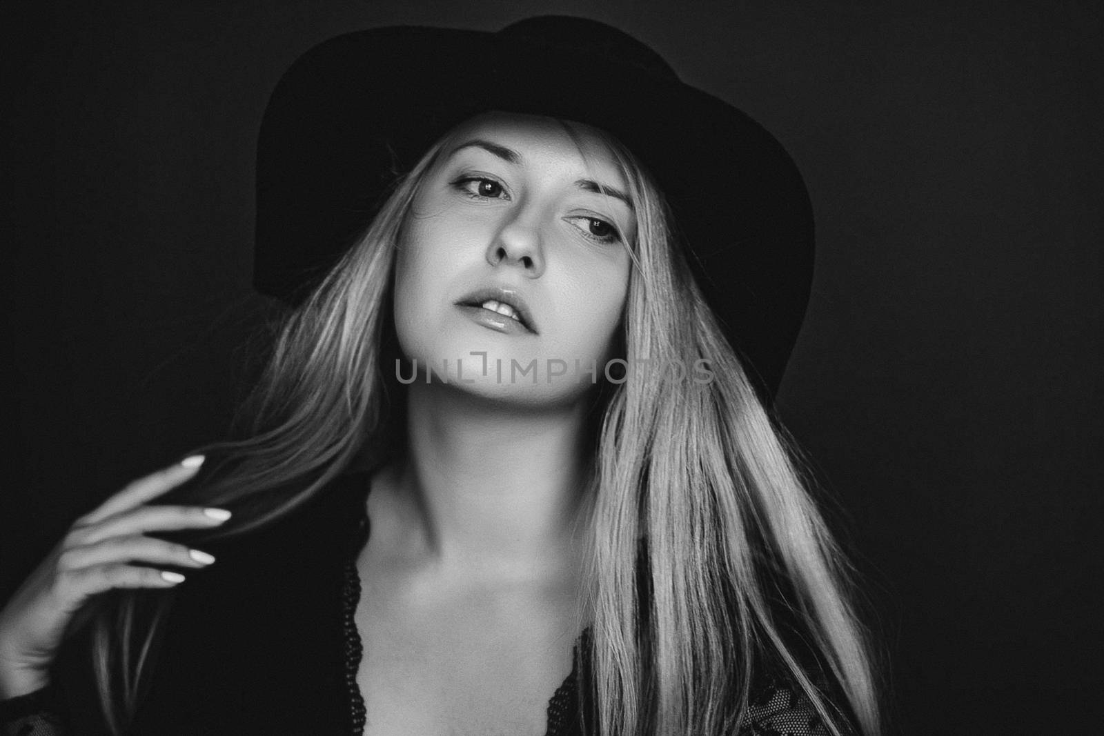 Beautiful blonde woman wearing a hat, artistic film portrait in black and white for fashion campaign and beauty brands