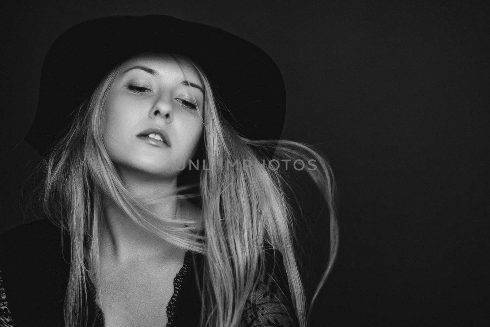 Beautiful blonde woman wearing a hat, artistic film portrait in black and white for fashion campaign and beauty brands