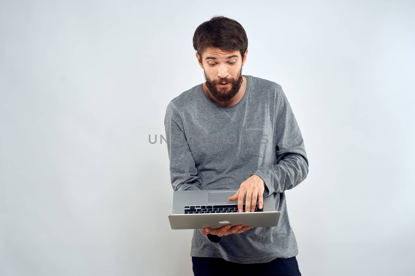 A man holding a laptop internet communication lifestyle technology light background studio. High quality photo