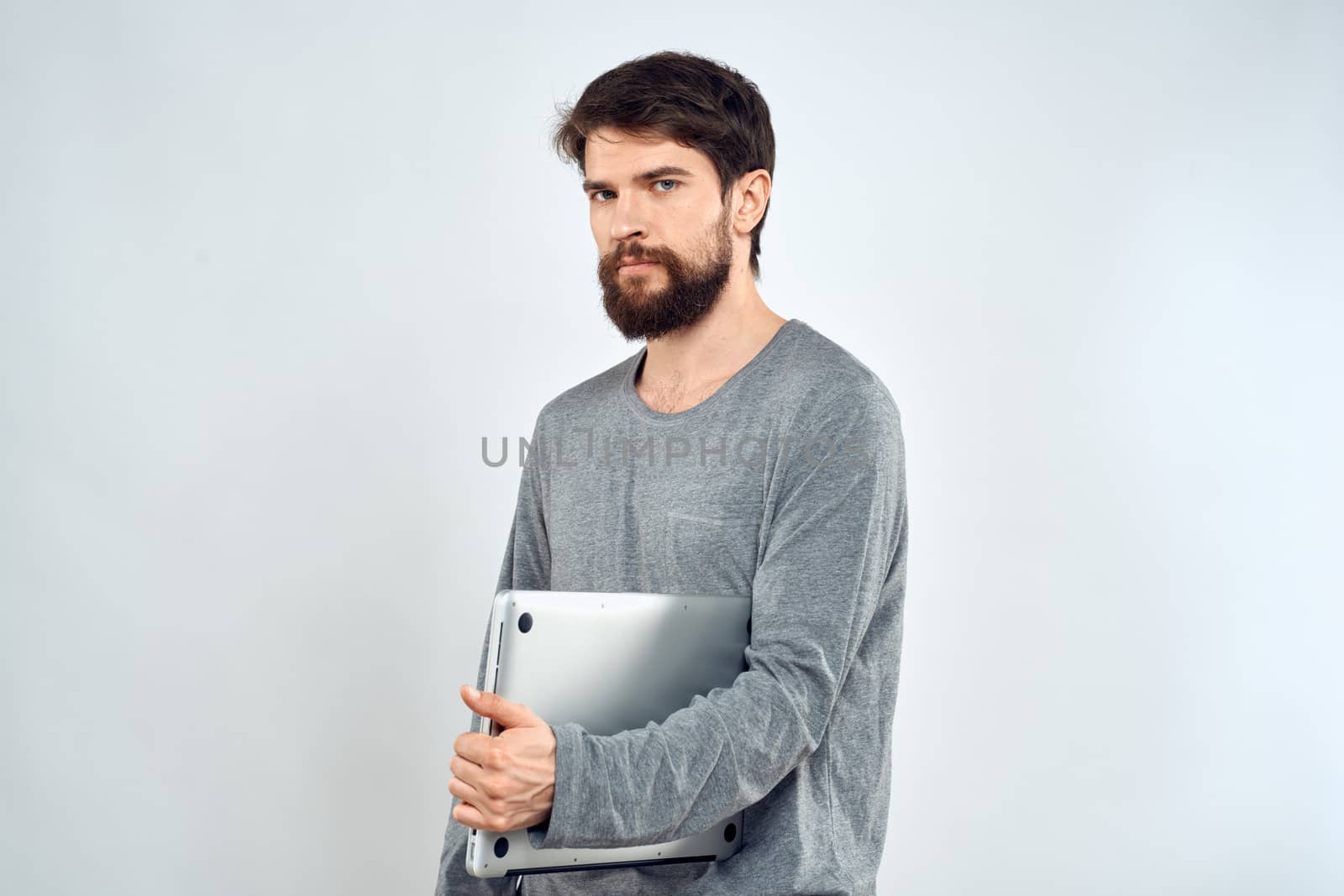 Emotional man holding a laptop success modern style work light background. High quality photo