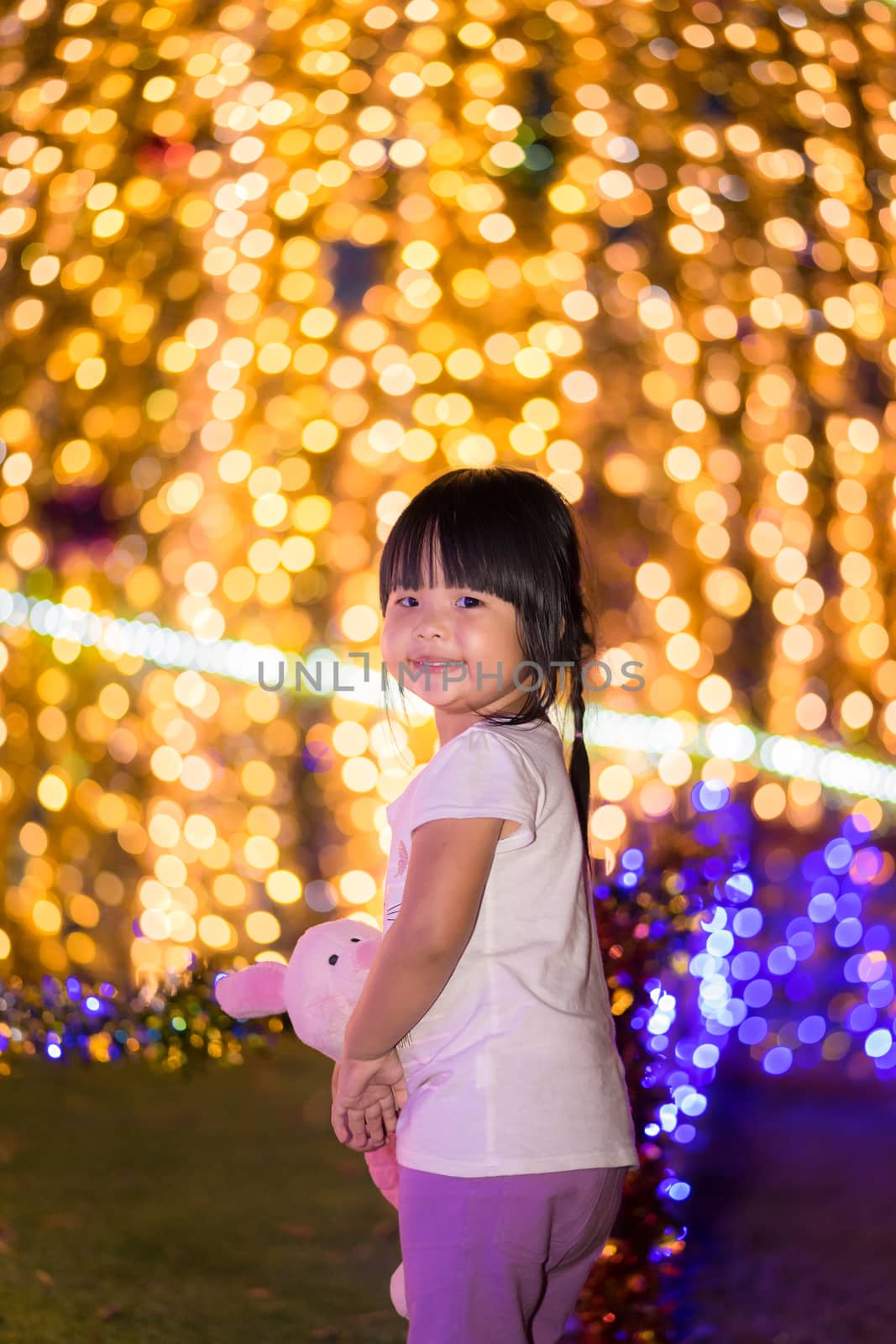 little asian girl hug doll and bokeh background on Christmas day