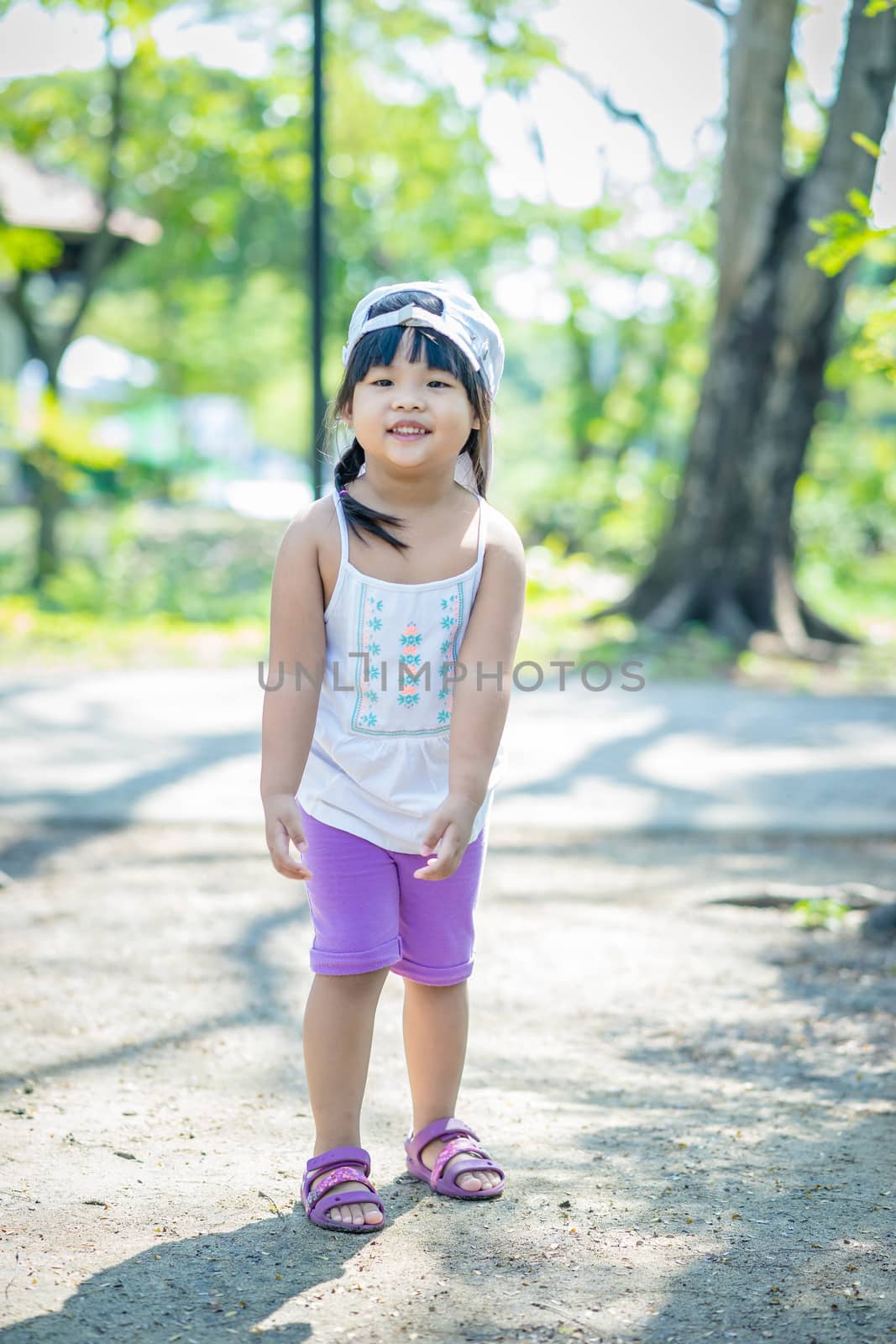 portrait of little girl wear hat walking in the park
