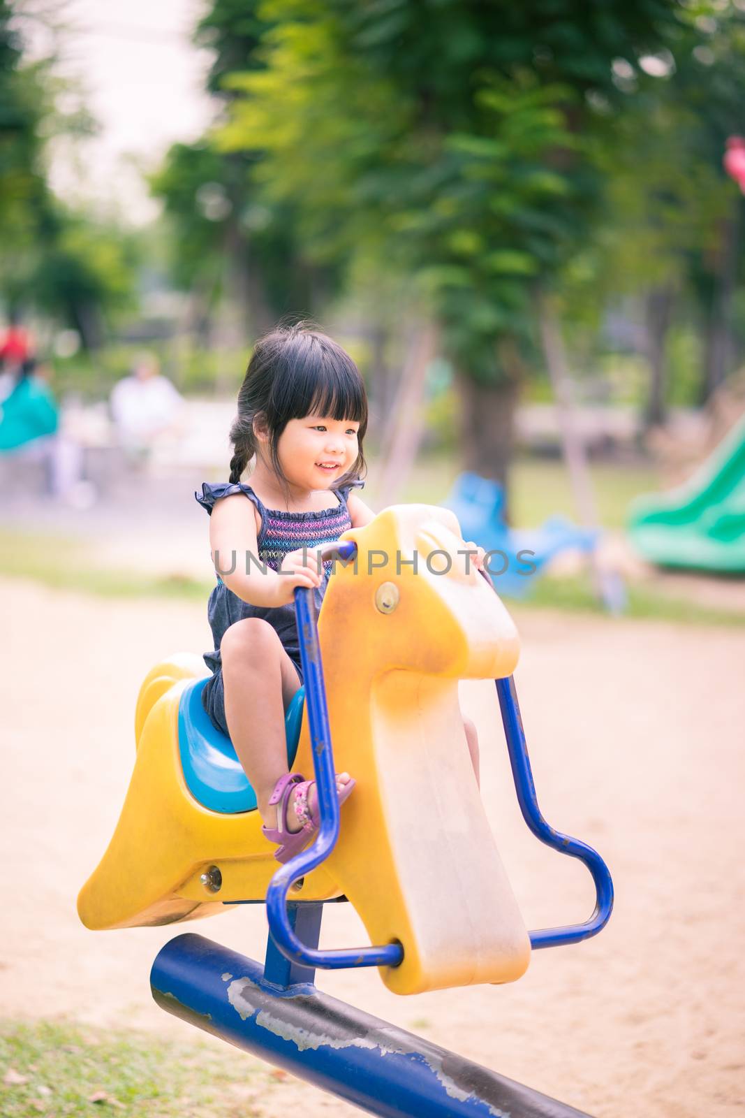 Asian little girl enjoys playing in a children playground