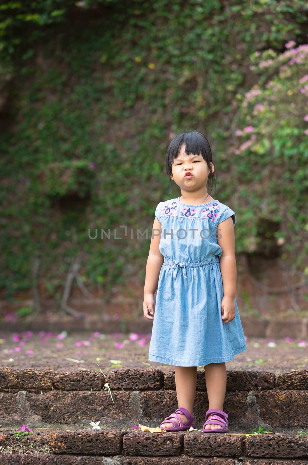 portrait of asian little girl puckered up her lips by domonite