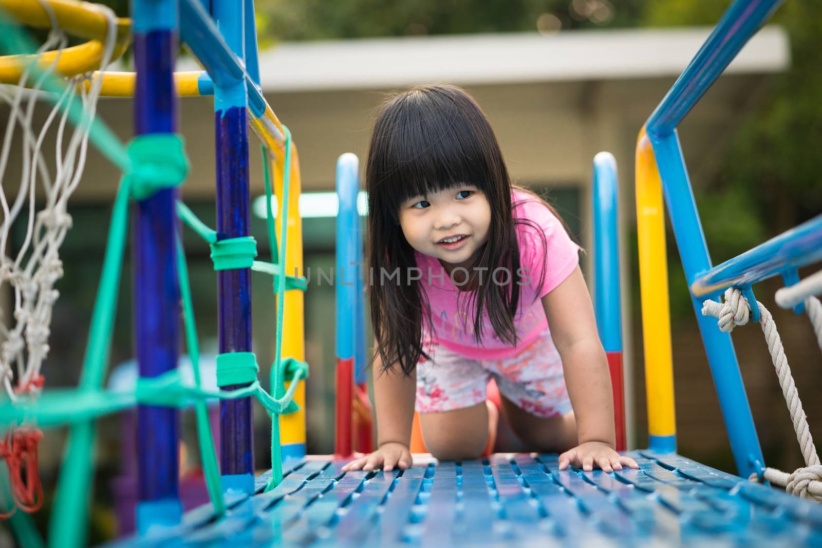 Asian little girl enjoys playing in a children playground