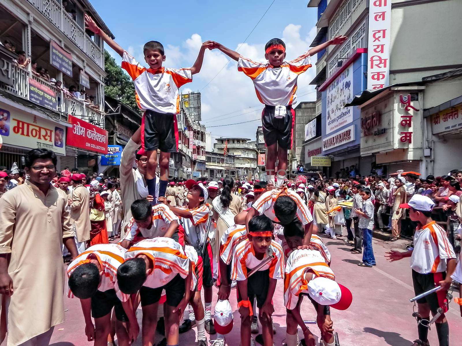 Acrobats doing gymnastic acts during Ganesh festival procession. by lalam